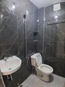 ein Badezimmer mit Toilette und Waschbecken in der Unterkunft Merlyn Donque in Cainta