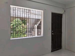 ein Zimmer mit einer Tür und einem Fenster und einer Tür in der Unterkunft Merlyn Donque in Cainta