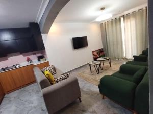 a living room with two couches and a tv at Cosy Homes in Gulu