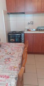 a kitchen with a table and a stove and a sink at Matenia’s house in Mángana