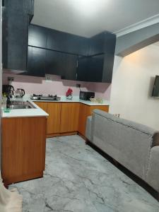 a kitchen with a couch in the middle of it at Cosy Homes in Gulu
