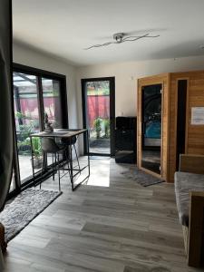 a living room with a table and glass doors at L'éphémère-Private Spa in Plérin