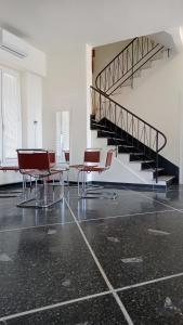 a room with chairs and a table and a staircase at Piccolo Hotel in Lavagna