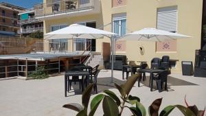 a patio with tables and chairs and umbrellas at Piccolo Hotel in Lavagna