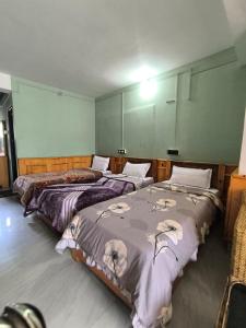 two beds sitting in a room with at Zen Homestay in Dirang Dzong