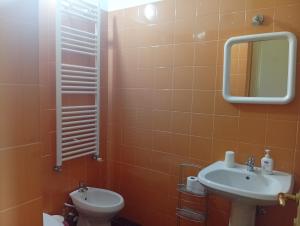 ein Badezimmer mit Waschbecken, Toilette und Spiegel in der Unterkunft Helly House in Isernia