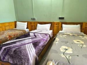 two beds sitting next to each other in a room at Zen Homestay in Dirang Dzong +21 photos