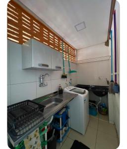 a small kitchen with a sink and a washing machine at House farol in Aracaju