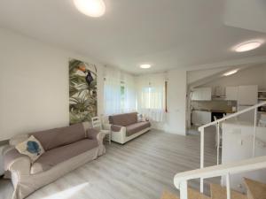 a living room with a couch and a kitchen at Villa Martina in Fregene +47 photos