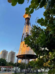 a tall tower in a park with buildings in the background at House farol in Aracaju