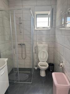 a bathroom with a toilet and a glass shower at Hubby Resort in Mostar +10 photos