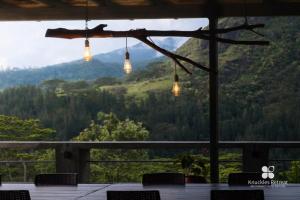 a view of a mountain from a restaurant with lights at Knuckles Retreat in Huluganga