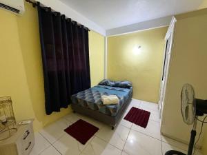 a small room with a bed and a shower at 2BR Guest Home - Dominica in Pointe Michel