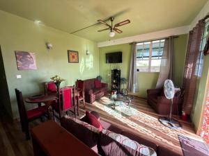 a living room with couches and a ceiling fan at 2BR Guest Home - Dominica in Pointe Michel +7 photos