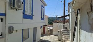 an alley with white buildings and blue shutters at Oikos Filon in Palaiókastron