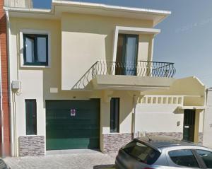 a house with a green garage and a car parked in front at Music Houses T3 in Espinho