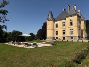 a castle with chairs and an umbrella in front of it at Coin de Paix - Château de Launay in Saint-Vincent-sur-Oust