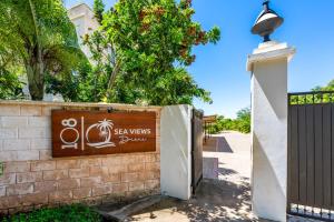 a sign on a brick wall next to a gate at Sandbox Apartment 4 Diani Beach Kenya in Ukunda +18 photos