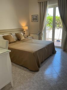 a bedroom with a large bed and a large window at Hotel Ristorante Colleverde in Santa Maria di Castellabate