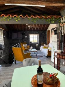 a bottle of wine on a table in a living room at Casinha de Pedra in Cais do Pico