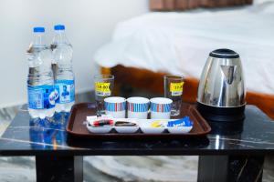 a tray with cups and drinks on a table at Shri Valli Rooms in Tiruvannāmalai