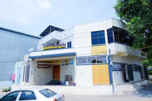 a building with a car parked in front of it at Shri Valli Rooms in Tiruvannāmalai