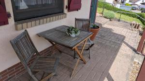 a wooden table and two chairs on a patio at Ferienwohnung Ella in Föckelberg