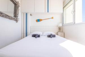 a bedroom with a large white bed with two pillows at Magnifique appartement avec vue mer panoramique ! in Valras-Plage