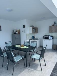 a dining room with a table and chairs and a kitchen at Hubby Resort in Mostar