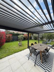 a wooden table and chairs on a patio at Maison Eguilles in Éguilles