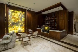 a lobby with chairs and a large painting on the wall at Grand Babl in Erbil