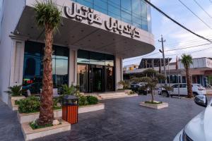 a store front with palm trees in front of it at Grand Babl in Erbil