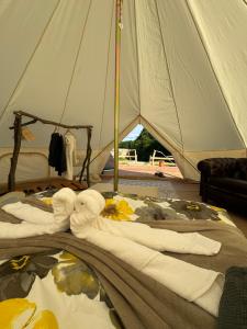 a bed in a tent with towels on it at Hupkac Glamping retreat in Vodranci