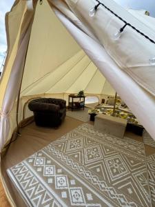 a tent with a bed and a chair in a room at Hupkac Glamping retreat in Vodranci