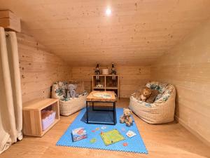 a toy room with two couches and a table at Charming family Chalet for 8 people, with private Hot Tub in Les Clefs