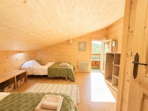 a bedroom with two beds in a wooden cabin at Charming family Chalet for 8 people, with private Hot Tub in Les Clefs