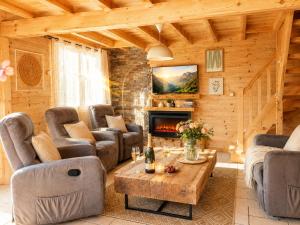 a living room with couches and a fireplace at Charming family Chalet for 8 people, with private Hot Tub in Les Clefs
