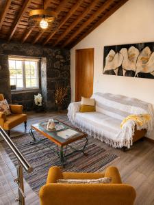 a living room with a couch and a table at Casinha de Pedra in Cais do Pico