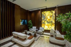 a living room with couches and chairs and a tv at Grand Babl in Erbil