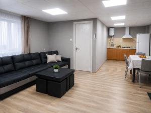 a living room with a black couch and a table at Bluebell Cottage in Tsalka