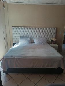 a large bed with a large headboard in a bedroom at Fourways guesthouse & spa in Fourways +1 photo