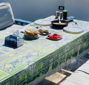 a table with a table cloth with food on it at Gîte Hôtel Ramla Louxor 2 in Luxor