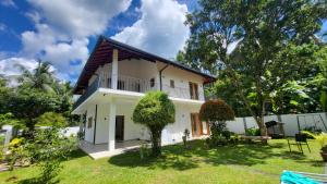 a view of a house with a yard at Parrot Paradise Negombo in Negombo