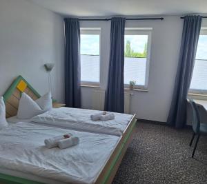 a bedroom with a bed with towels on it at Hotel am Zellwald in Großschirma