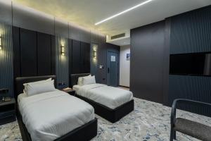 a hotel room with two beds and a flat screen tv at Grand Babl in Erbil +52 photos
