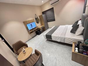 a hotel room with a bed and a table and chairs at Hotel Stayvilla Raipur in Raipur