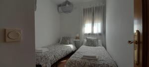 a bedroom with two beds and a window at Casa rural El Yelmo in Miguel Esteban
