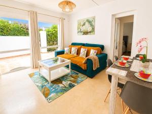 a living room with a blue couch and a table at Cristina Bungalow in Estepona