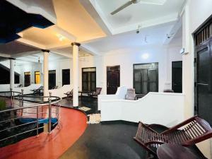 a living room with a white couch and chairs at Golden Breeze Arugambay in Arugam Bay