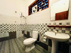 a bathroom with a toilet and a sink at Golden Breeze Arugambay in Arugam Bay